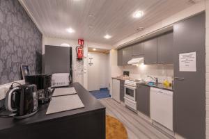 a kitchen with black and white cabinets and appliances at Kuukkeli Saariselkä Inn in Saariselka +37 photos