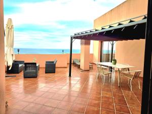 a patio with a table and chairs and the beach at CN-340 Suites in Estepona
