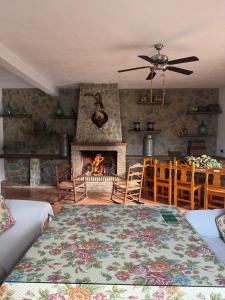 a living room with a fireplace and a table and chairs at Cortijo Loma del Estanque in Monachil
