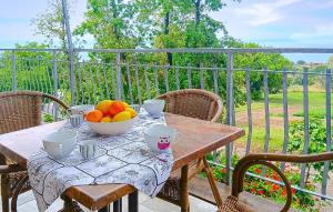 a wooden table with a bowl of fruit on a balcony at Cozy Apartment In Ricadi With Wifi in Ricadi