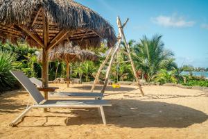 two chairs and an umbrella on a beach at Soma Bay - Incredible Seaside Apartment in Tamarin