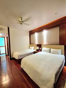 a hotel room with two beds with white sheets at Pandora Hotel Cần Thơ in Can Tho