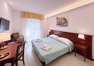a bedroom with a bed and a desk and a table at Hotel Villa Adriana in Monterosso al Mare +37 photos