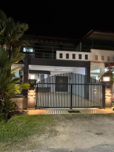 a white fence in front of a house at night at JL Homestay Bahau in Bahau