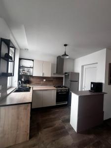 a kitchen with white cabinets and a black stove at Confortable Maison in Les Rues-des-Vignes