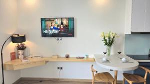 un salon avec une table et une télévision au mur dans l'établissement Vinhomes Greenbay Studio Luxury Apt #Jerry's House, à Hanoï 11 autres photos