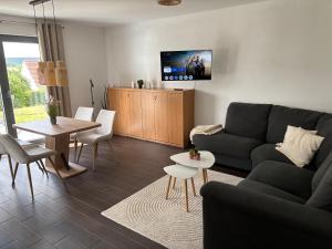 a living room with a couch and a table at Gemütliche Ferienwohnung mit Sonnenterrasse in Schlitz