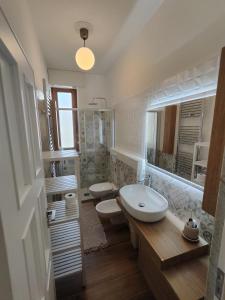 a bathroom with two toilets and a sink and a mirror at Corsica 23 - Affitti Brevi Italia in Gravina in Puglia