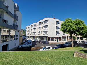 a parking lot with cars parked in front of a building at Apartamento Villa Paioryna II in Vila Verde