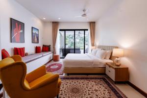 a bedroom with a bed and a chair and a couch at Villa Viola 7 Bedroom, Fully Staffed, on the Golf Course in Laguna Phuket +103 photos