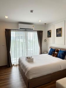 a bedroom with a large bed with a teddy bear on it at Joy house 1 bedroom Lahabana HuaHin in Hua Hin
