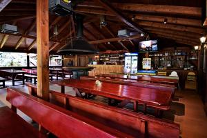 un ristorante con panche in legno e un bar di Apartmány & Kemp Sázavský ostrov a Sázava