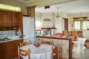 a kitchen and living room with a table and a kitchen at Korinthos House PLV in Bolátion