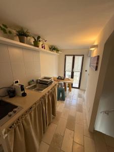 eine Küche mit einem Waschbecken und einem Tisch darin in der Unterkunft Dimore N&N in Polignano a Mare