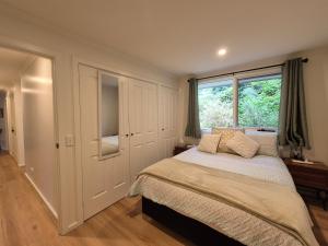 a bedroom with a bed and a window at Grey Gum Getaway Tecoma in Belgrave