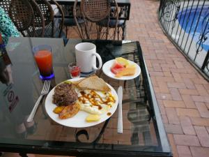 a table with two plates of breakfast foods and a drink at Hotel Santo Tomás in San José +145 photos