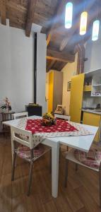 a white table and chairs in a room with a kitchen at Casa Vacanze La Stele in Castelmonte +15 photos