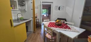 a small kitchen with a table with a red and white table cloth at Casa Vacanze La Stele in Castelmonte