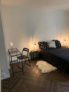 a bedroom with a bed and a chair and a table at Unique apartment on the prestige address in Helsinki
