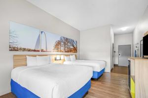 a hotel room with two beds and a tv at Days Inn by Wyndham Collinsville St Louis in Collinsville +25 photos
