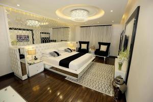 a bedroom with a large bed and a chandelier at Ramada by Wyndham Multan in Multan