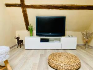 a living room with a tv on a white cabinet at Casa del Sol in Schwaigern