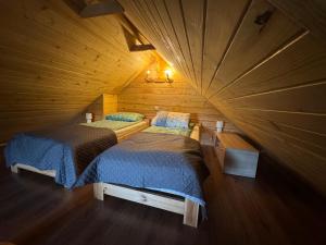 a room with two beds in a wooden cabin at Na Piaskach Agroturystyka Domek pod Lipą in Narol