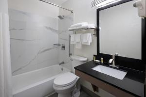 a bathroom with a toilet and a sink and a shower at Super 8 by Wyndham Richmond Midlothian Turnpike in Midlothian +26 photos