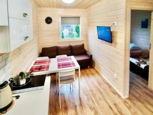 a small kitchen with a couch in a tiny house at Domki Letniskowe SOHO in Bobolin