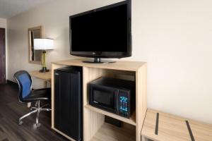 a room with a tv and a microwave in a hotel room at Super 8 by Wyndham South Boston VA in South Boston