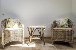 two wicker chairs and a table in a room at Hofgut Dösterhof - Hotelzimmer in Wadern