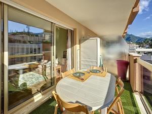 un balcon avec une table et des chaises sur un balcon dans l'établissement Hello Menton, à Menton 15 autres photos