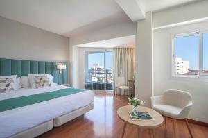 a hotel room with a bed and a table and a chair at Hotel Costa Málaga - Adults Recommended - by Pierre & Vacances in Torremolinos