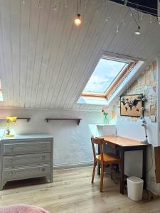a attic room with a table and a window at Maison tout confort proche Disneyland avec Jardin, BBQ & parking privé in Esbly