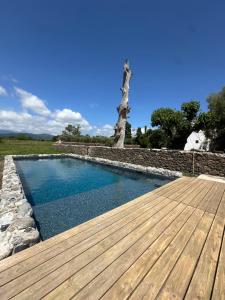 a swimming pool with a wooden floor and a wooden deck at U Vermentinu in Aghione