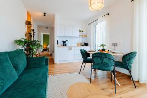 a living room with a green couch and a table at hestlehomes - Stadtvilla Leine - PARKING, ZENTRAL & ÖPNV NAH in Göttingen