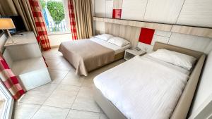 a small bedroom with two beds and a window at Hotel Slovenska Plaza in Budva