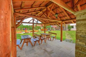 a wooden pavilion with picnic tables and benches in a park at Willa Roma in Brenna