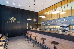 a restaurant with a counter with stools and a bar at nhow Frankfurt in Frankfurt