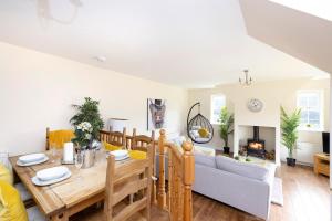 a dining room and living room with a table and a couch at JOIVY Greenknowes Cottage with Hot Tub & Fireplace in Kelty