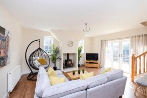 a living room with a couch and a tv at JOIVY Greenknowes Cottage with Hot Tub & Fireplace in Kelty