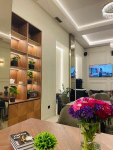 a room with a table with flowers on it at Move In Aparthotel in Belgrade