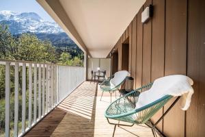 2 sedie su un balcone con vista sulle montagne sullo sfondo di Apartment Omas Les Houches - by EMERALD STAY a Les Houches