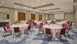 a conference room with white tables and red chairs at Hyatt Regency London Blackfriars in London