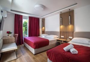 a hotel room with two beds and a window at Hotel Slovenska Plaza in Budva
