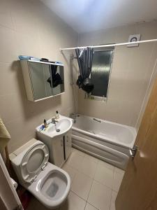 a bathroom with a toilet and a sink and a tub at 2 Double Bed Apartment Central London in London