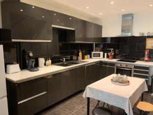 a kitchen with black and white appliances and a table at La Motte Forte in Arnay-le-Duc