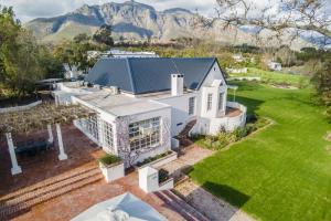 an aerial view of a white house with mountains in the background at Sunset Farm Stellenbosch in Stellenbosch