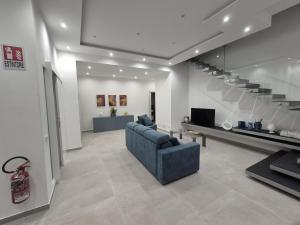 a living room with a blue couch and stairs at Villa Stesicoro Suite in Mondello