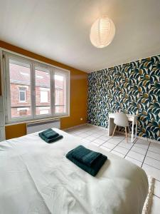 a bedroom with a bed and a table and a chair at L épicentre Gare d Amiens in Amiens